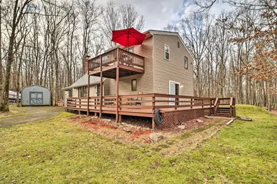 a house with a red umbrella on top of it at Near Big Boulder Mtn Cabin with Furnished Deck in Albrightsville