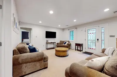 a living room with couches and a flat screen tv at 6 Fieldstone Ct in Lake Harmony