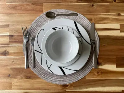 a plate and fork on a wooden table with a cup anducer at Spacious Pocono Home with Hot Tub and Fire Pit in Long Pond