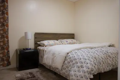 a bedroom with a bed and a lamp on a table at Mamas Love 2bedroom Spacious Apartment in Newark