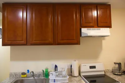 a kitchen counter with wooden cabinets and a sink at Mamas Love 2bedroom Spacious Apartment in Newark