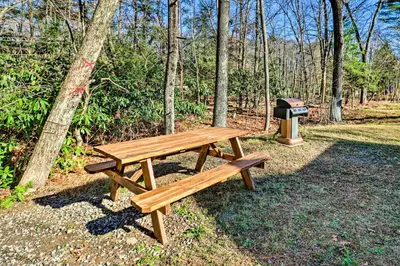a wooden picnic table in a park with a trash can at Cozy Tannersville Gem - Ski, Hike, Explore! in Tannersville