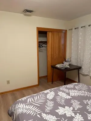 a bedroom with a bed and a table and a door at New Brunswick NJ Master Bedroom with private bath in New Brunswick