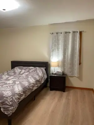 a bedroom with a bed and a lamp and a window at New Brunswick NJ Master Bedroom with private bath in New Brunswick