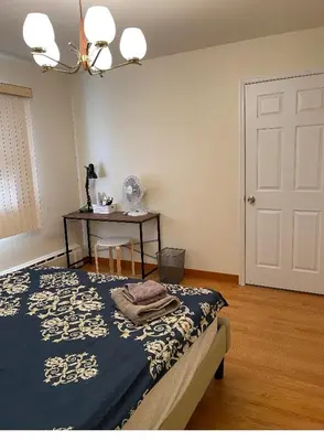 a bedroom with a bed and a table and a door at #1 Bright Private Room near New Brunswick, NJ downtown in New Brunswick