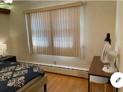 a bedroom with a bed and a window with a fan at #1 Bright Private Room near New Brunswick, NJ downtown in New Brunswick