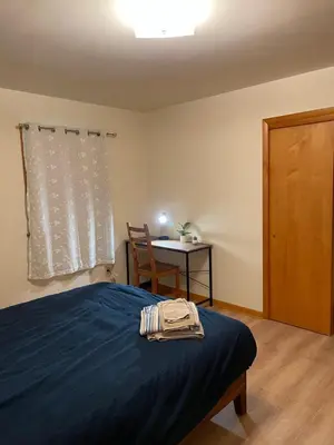 a bedroom with a blue bed with a chair and a table at #3 QueenSize Bed bright room near New Brunswick NJ downtown in New Brunswick