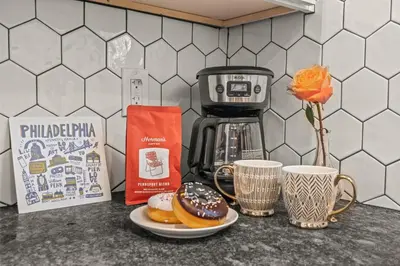 a counter with two plates of donuts and a coffee maker at Kid-Friendly Fishtown Family Retreat with Game Room in Philadelphia