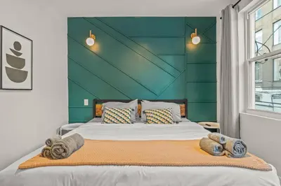 a bedroom with a large bed with a green wall at Kid-Friendly Fishtown Family Retreat with Game Room in Philadelphia