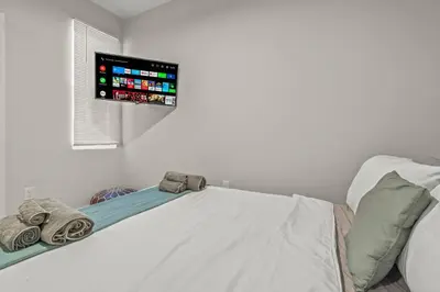 a bedroom with a bed with a tv on the wall at Kid-Friendly Fishtown Family Retreat with Game Room in Philadelphia