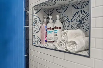 a shelf in a bathroom with toiletries and towels at Kid-Friendly Fishtown Family Retreat with Game Room in Philadelphia