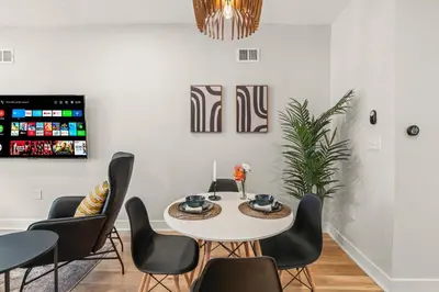 a dining room with a white table and chairs at Family Fun South Philly Game House Near Sports Stadiums and Concerts in Philadelphia