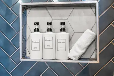 a shelf with four bottles of soap and a towel at Family Fun South Philly Game House Near Sports Stadiums and Concerts in Philadelphia