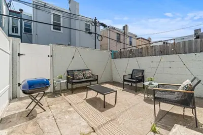 a patio with chairs and a grill and a fence at Family Fun South Philly Game House Near Sports Stadiums and Concerts in Philadelphia