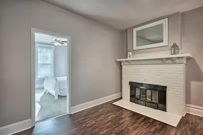 a living room with a fireplace and a chair at Suites on Seneca - Lovely 2 Bed 1 Bath Apartment in Harrisburg