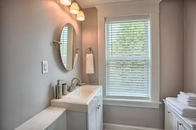 a bathroom with a sink and a mirror and a window at Suites on Seneca - Beautiful 1 Bedroom Apartment in Harrisburg