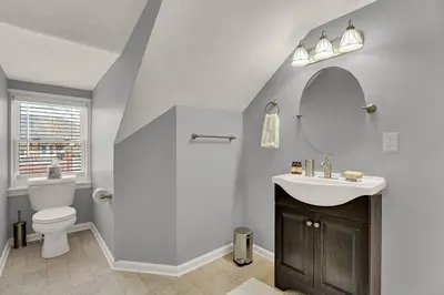 a bathroom with a toilet and a sink and a mirror at Suites on Seneca - Gorgeous One Bedroom Apartment in Harrisburg