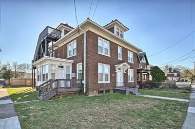 a large brick house with a porch and a balcony at Suites on Seneca - Gorgeous One Bedroom Apartment in Harrisburg