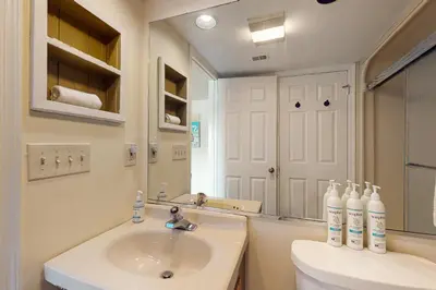 a bathroom with a sink and a toilet and a mirror at Midlake Memories in Lake Harmony