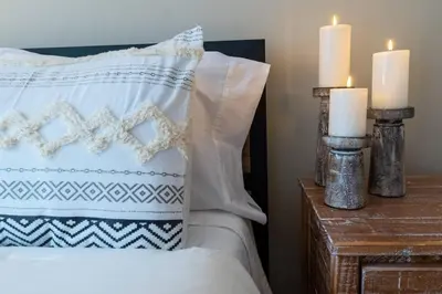 a bedroom with a bed with two candles and two pillows at Charming Corner Newly Furnished Townhome in Lake Harmony