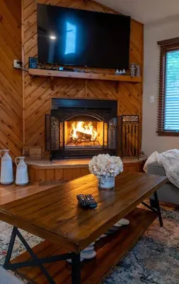 a living room with a fireplace and a wooden table at Charming Corner Newly Furnished Townhome in Lake Harmony