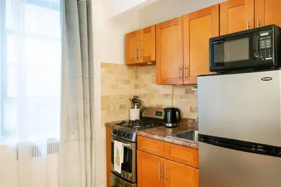 a kitchen with a refrigerator and a microwave at 105-1G Park Ave Location studio best value Sleeps3 in New York