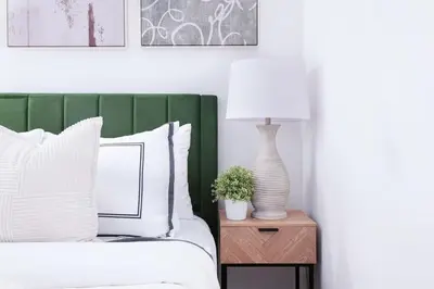 a bed with a green headboard and a lamp on a table at 105-1G Park Ave Location studio best value Sleeps3 in New York