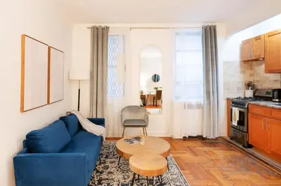 a living room with a blue couch and a table at 105-1G Park Ave Location studio best value Sleeps3 in New York