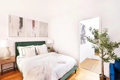 a bedroom with a bed with a green headboard and a mirror at 105-1G Park Ave Location studio best value Sleeps3 in New York
