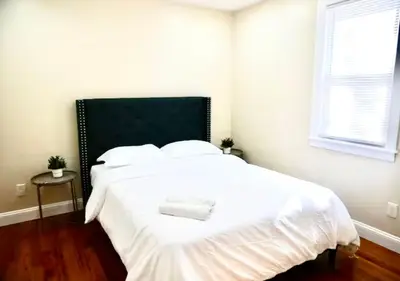 a white bed with a black headboard in a bedroom at Newly Renovated Guest Rooms near Transportation in Philadelphia