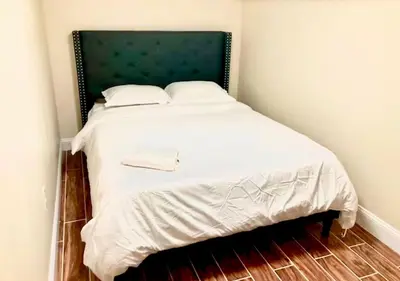 a bedroom with a white bed with a green headboard at Newly Renovated Guest Rooms near Transportation in Philadelphia