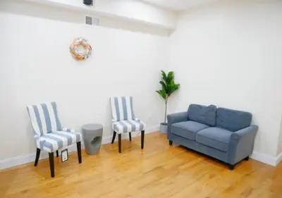 a living room with two chairs and a blue couch at Newly Renovated Guest Rooms near Transportation in Philadelphia