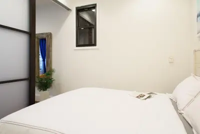 a bedroom with a white bed and a mirror at 69-2B Prime Lower East East BRAND NEW 1br Apt in New York