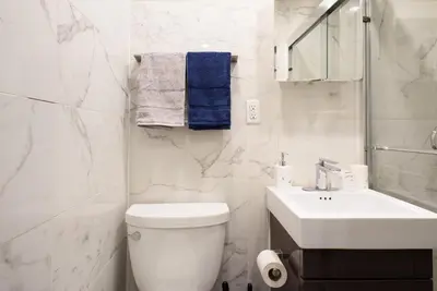 a white bathroom with a toilet and a sink at 69-2B Prime Lower East East BRAND NEW 1br Apt in New York