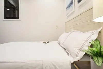 a bedroom with a bed with white sheets and pillows at 69-2B Prime Lower East East BRAND NEW 1br Apt in New York