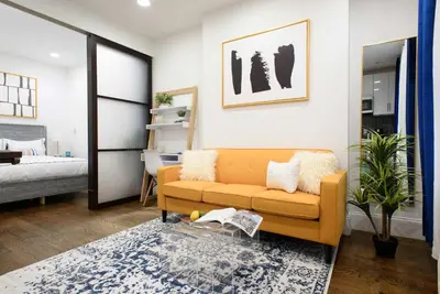 a living room with a couch and a bedroom at 69-2A PRIME Lower East Side 1br Apt Brand New in New York