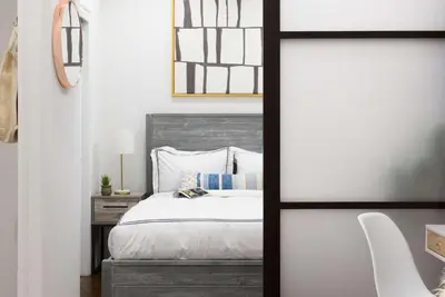 a bedroom with a bed and a table with a chair at 69-2A PRIME Lower East Side 1br Apt Brand New in New York