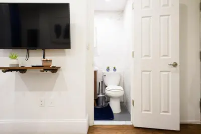 a bathroom with a toilet and a tv on a wall at 69-2A PRIME Lower East Side 1br Apt Brand New in New York