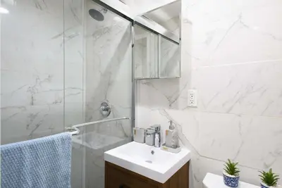 a white bathroom with a sink and a shower at 69-2A PRIME Lower East Side 1br Apt Brand New in New York