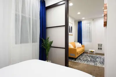 a bedroom with a bed and a living room at 69-2A PRIME Lower East Side 1br Apt Brand New in New York