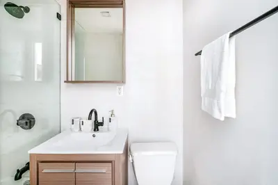 a white bathroom with a sink and a mirror at 69-2C Brand New PRIME Lower East Side 1br Apt in New York