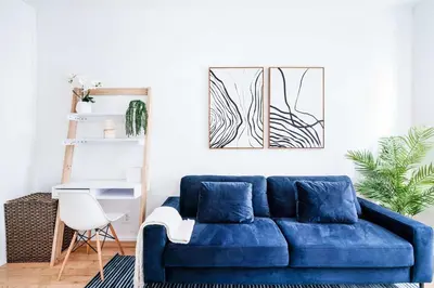 a blue couch in a living room with a desk at 69-2C Brand New PRIME Lower East Side 1br Apt in New York