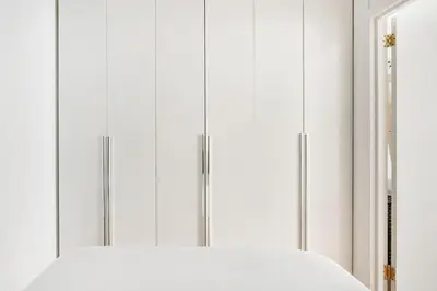 a white wardrobe with two doors and a mirror at 69-2C Brand New PRIME Lower East Side 1br Apt in New York
