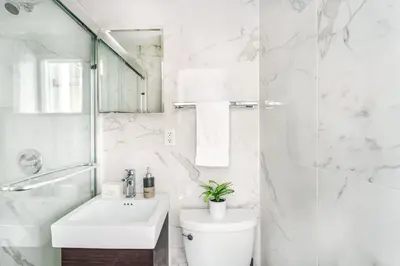 a white bathroom with a toilet and a sink at 69-3A Prime LES Modern Brand New 1BR in New York