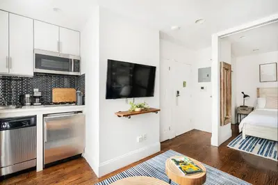 a living room with a kitchen and a bed at 69-3A Prime LES Modern Brand New 1BR in New York