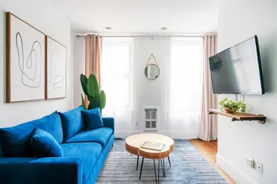 a living room with a blue couch and a tv at 69-3A Prime LES Modern Brand New 1BR in New York