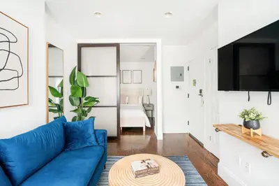 a living room with a blue couch and a table at 69-3B Prime Lower East Side BRAND NEW 1br Apt in New York