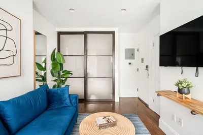 a living room with a blue couch and a table at 69-3B Prime Lower East Side BRAND NEW 1br Apt in New York