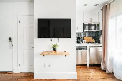 a white kitchen with a tv on a wall at 69-3B Prime Lower East Side BRAND NEW 1br Apt in New York