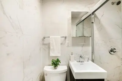a white bathroom with a sink and a toilet at 69-3B Prime Lower East Side BRAND NEW 1br Apt in New York